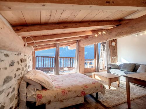 une chambre avec un lit et une grande fenêtre dans l'établissement calme et vue, à Montvalezan