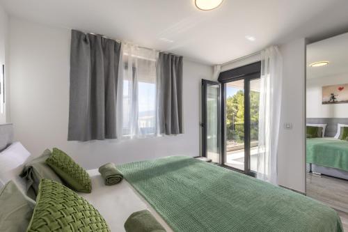 a bedroom with a green bed and a window at Apartment Island Krk Queen 1 in Krk