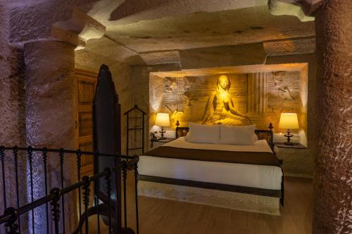 a bedroom with a large buddha statue on the wall at Utopia Cave Cappadocia in Urgup