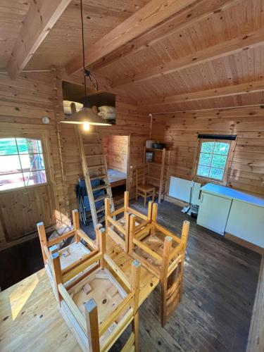 a room with a table and chairs in a log cabin at Steiner's Camping & Lodge in Johannisholm