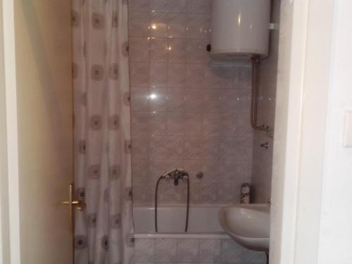 Un baño con ducha con bañera y lavabo. en Bubin apartman, en Novi Beograd