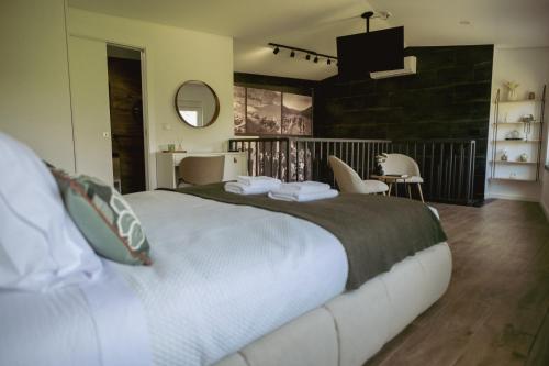 a bedroom with a large bed and a table and chairs at Casa da Adega in Vila Nova de Foz Coa