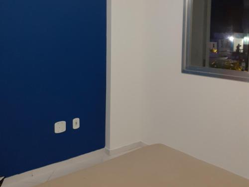皮烏馬的住宿－Apartamento 101 com vista da piscina e mar，一间设有蓝色墙壁和窗户的客房