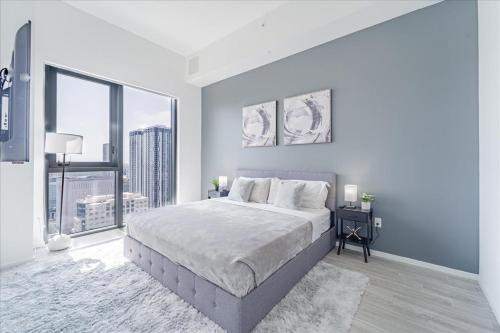 a white bedroom with a large bed and a large window at TR Miami 2 Bedroom, 1 Bedroom, and Studio Condos with Balconies in Miami