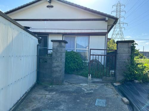 a white house with a gate and a fence at アルピエm 敷地内無料駐車場2台分 置き型無料Wi-Fiあります 平屋瓦屋根の日本家屋 in Arao