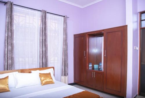 a bedroom with a bed and a cabinet and a window at Arusha Hideway Resort in Old Moshi