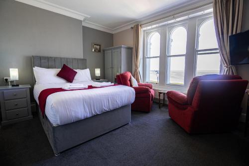 a hotel room with a bed and a chair at The Central Hotel in Llandudno