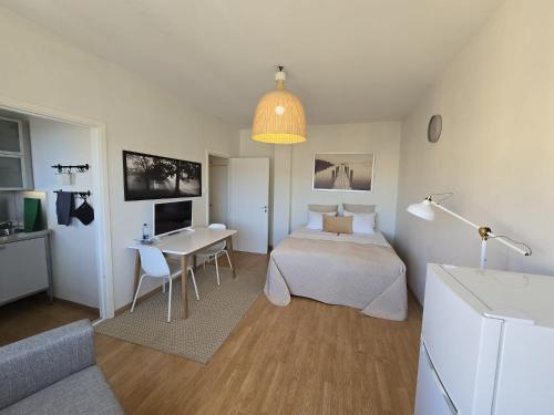 a bedroom with a bed and a table and a desk at Borent Suite Apartment in Turku