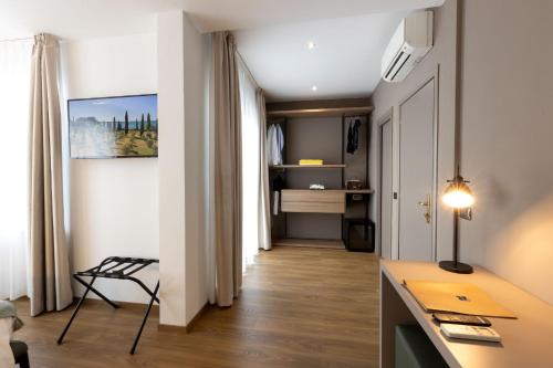 a room with a hallway with a desk and a bedroom at Piccolo Hotel in Malcesine