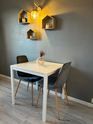 une table blanche avec deux chaises et un dispositif lumineux dans l'établissement Au cocon du palais, à Avignon