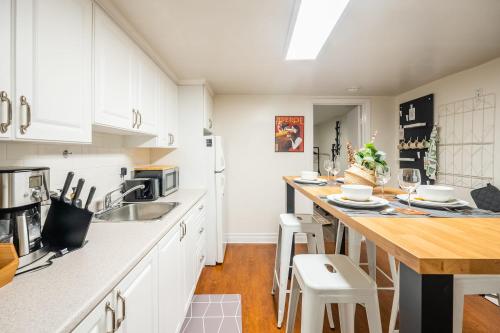 eine Küche mit weißen Schränken und einer Arbeitsplatte in der Unterkunft Modern 2BR Apt - Close to Trinity Bellwoods Park in Toronto