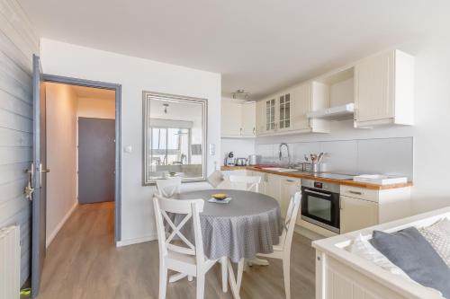 une cuisine et une salle à manger avec une table et des chaises dans l'établissement Studio Soleil Couchant - Vue mer, à Saint-Jean-de-Monts