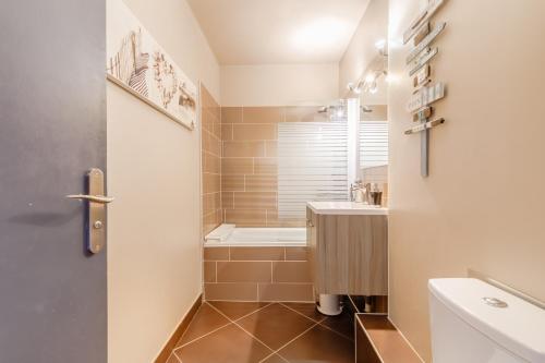 une salle de bain avec un lavabo et une baignoire dans l'établissement Studio Soleil Couchant - Vue mer, à Saint-Jean-de-Monts
