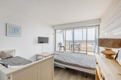 une chambre avec un lit et une vue sur l'océan dans l'établissement Studio Soleil Couchant - Vue mer, à Saint-Jean-de-Monts