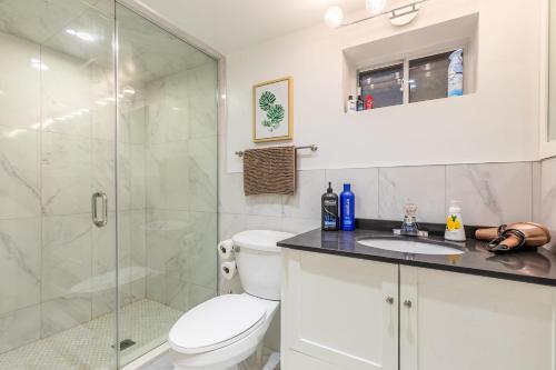 a bathroom with a shower and a toilet and a sink at 2 Bedroom Apartment in the Heart of Trinity Bellwoods in Toronto