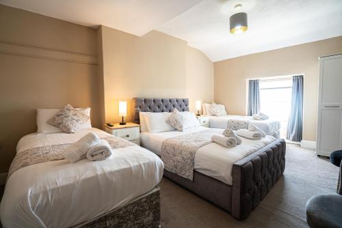 a bedroom with two beds with towels on them at The Central Hotel in Llandudno