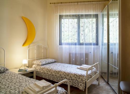 a room with two beds and a window with a mirror at Villa Laura in Toscolano Maderno