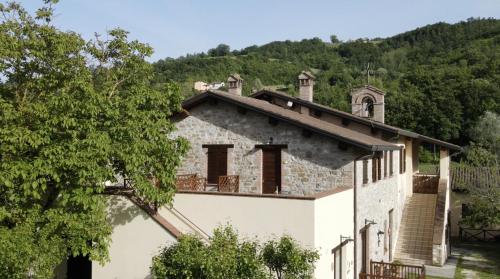 an old white house with a hill in the background at Domus Laetitiae Santa Croce in Gualdo Tadino