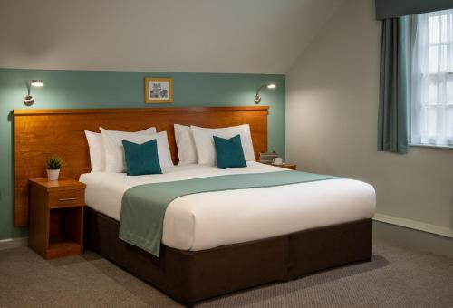 a bedroom with a large bed with blue pillows at Middletons in York