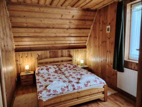 Ódon Panzió في بوكسزينتخيرسزت: غرفة نوم بسرير في غرفة خشبية