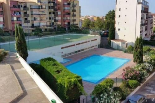 une grande piscine avec un court de tennis dans l'établissement T3 CAP d'Agde : vue imprenable mer RDC, au Cap d'Agde