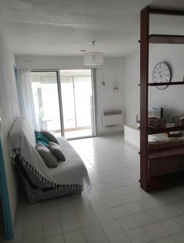 une chambre avec un lit et une horloge au mur dans l'établissement T3 CAP d'Agde : vue imprenable mer RDC, au Cap d'Agde
