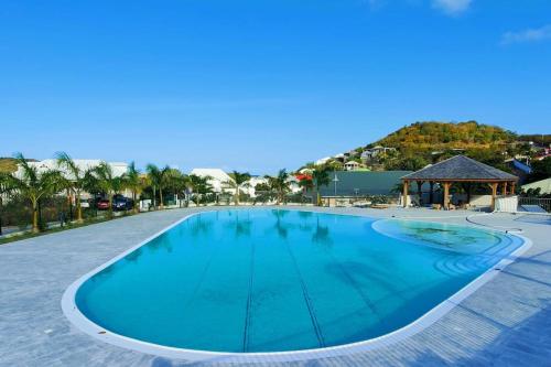 a large blue swimming pool with a gazebo at Natural Lodge in Cul de Sac