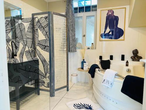 a bathroom with a shower and a bathtub with a shower at L'Escapade marine appartement avec jacuzzi privé in Cayeux-sur-Mer