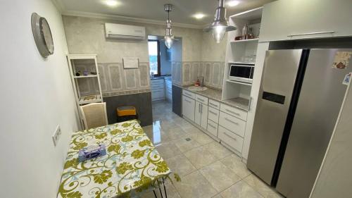 uma cozinha com uma mesa e um frigorífico em Квартира возле парка Софиевка em Uman