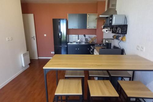 une cuisine avec une table, des chaises et un réfrigérateur dans l'établissement Appartement 3 pièces avec parking et balcon - Le Havre, au Havre