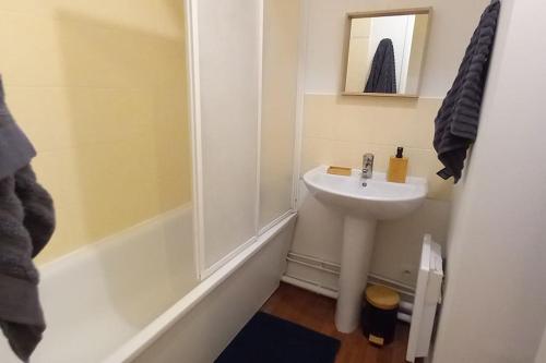 une salle de bain blanche avec un lavabo et une douche dans l'établissement Appartement 3 pièces avec parking et balcon - Le Havre, au Havre