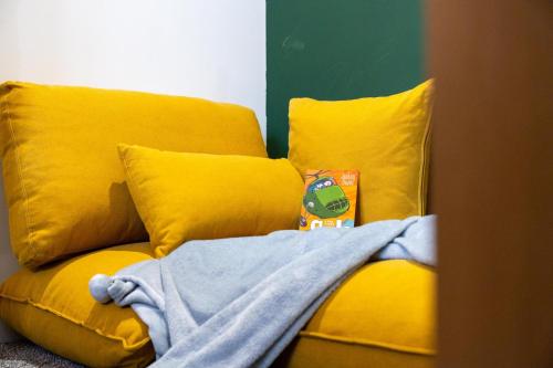 - un canapé jaune avec une couverture dans l'établissement Cozy 2-Bedroom - Cyncoed Area, à Cardiff