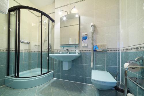 La salle de bains est pourvue d'un lavabo, de toilettes et d'une douche. dans l'établissement Hotel Perła Bieszczadów Geovita, à Czarna