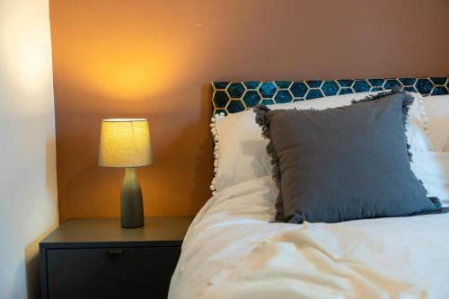 - une chambre avec un lit et une lampe sur une table de chevet dans l'établissement Cozy 2-Bedroom - Cyncoed Area, à Cardiff