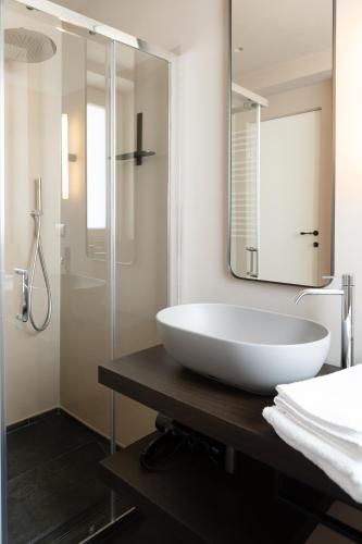 a bathroom with a large white sink and a shower at La Martina Home in Valguarnera Caropepe