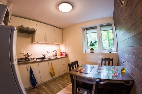 a kitchen with a wooden table and a table and chairs at Siedlisko Basiówka in Alfredówka