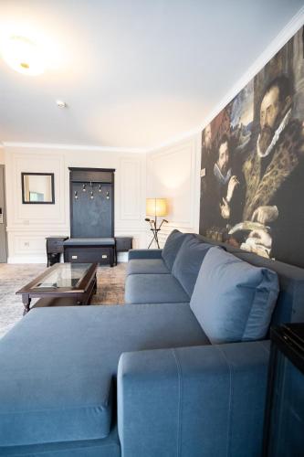 a living room with a blue couch and a painting at Hotel Meridian in Cluj-Napoca