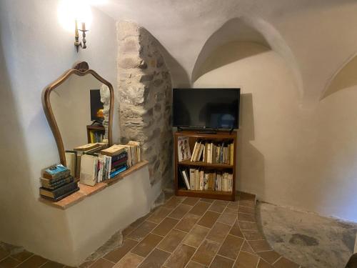 a hallway with a tv and a shelf with books at La Casa Medievale Suites e SPA in Pontremoli