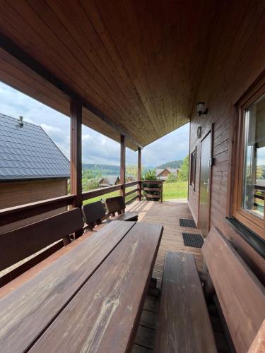 a wooden porch with benches and a large window at RESET INN in Zawóz