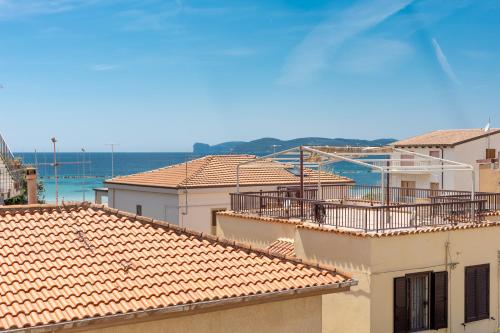 una vista de los tejados de los edificios y del océano en MaBi en Alghero