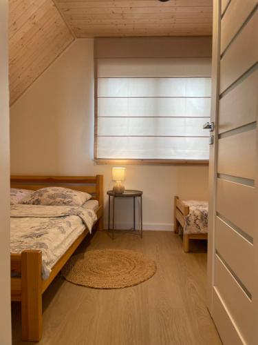 a bedroom with a bed and a window and a table at RESET INN in Zawóz