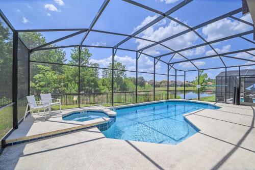 a swimming pool in a glass house at Upstay 9BR Disney Retreat w Pool, BBQ & Hot Tub in Kissimmee