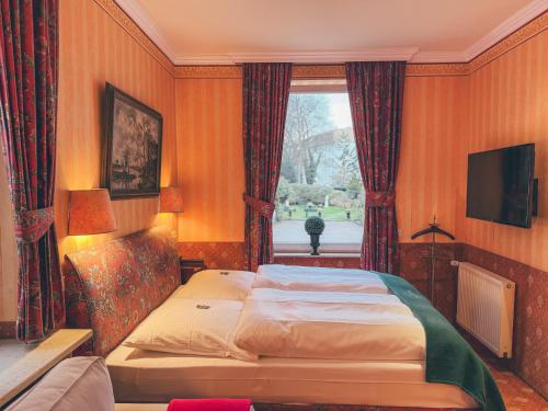 um quarto com uma cama grande e uma janela em Hotel Mittelweg em Hamburgo