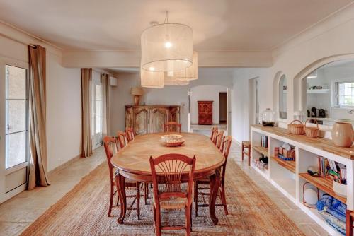 une cuisine et une salle à manger avec une table et des chaises en bois dans l'établissement LE KEY WEST maison de charme avec splendide jardin et piscine magnifique, Mougins près de Cannes, à Mougins