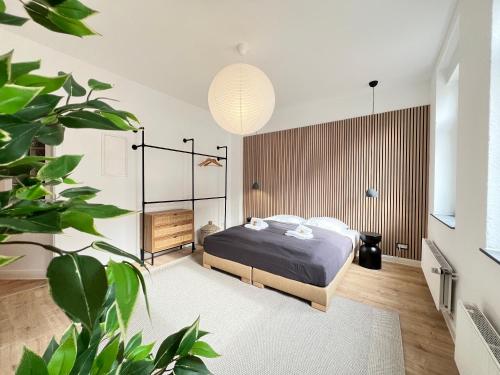 um quarto com uma cama e um vaso de plantas em FLATLIGHT - Stylish apartment - Kitchen - Parking - Netflix em Hildesheim