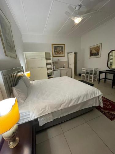 a bedroom with a large white bed in a room at Green Olive Guesthouse in Robertson