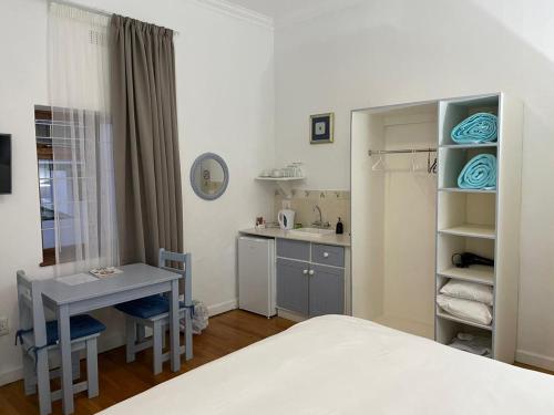 a bedroom with a bed and a desk and a sink at Green Olive Guesthouse in Robertson