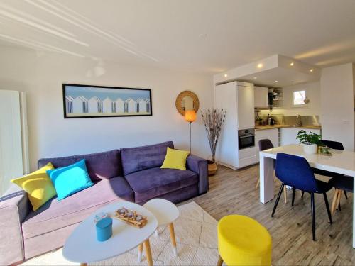 a living room with a purple couch and a table at Les Embruns / F2 Hyper centre Houlgate in Houlgate