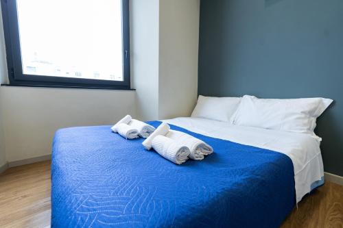 a bedroom with two towels on a blue bed at PIENO CENTRO - 3 min ACQUARIO in Genova
