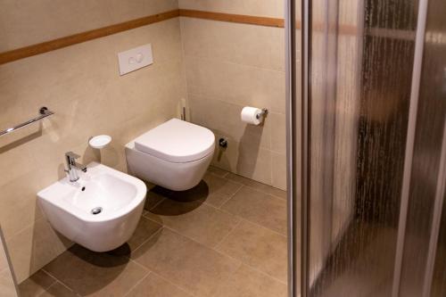 a bathroom with a toilet and a sink and a shower at Alpen Garten Hotel Margherita in Rumo